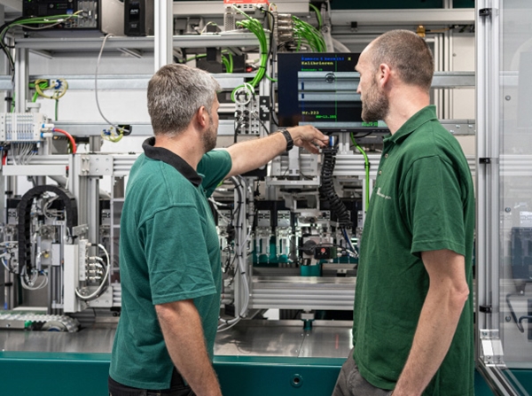 Two persons working with machinery.